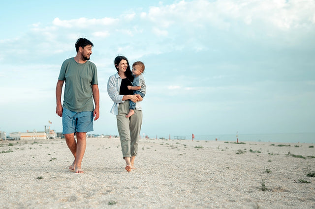 The P Word our potty training program empowers parents using the Montessori approach. Parents walking across a beach with their toddler.