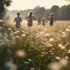 Family running across a field in the summer sun